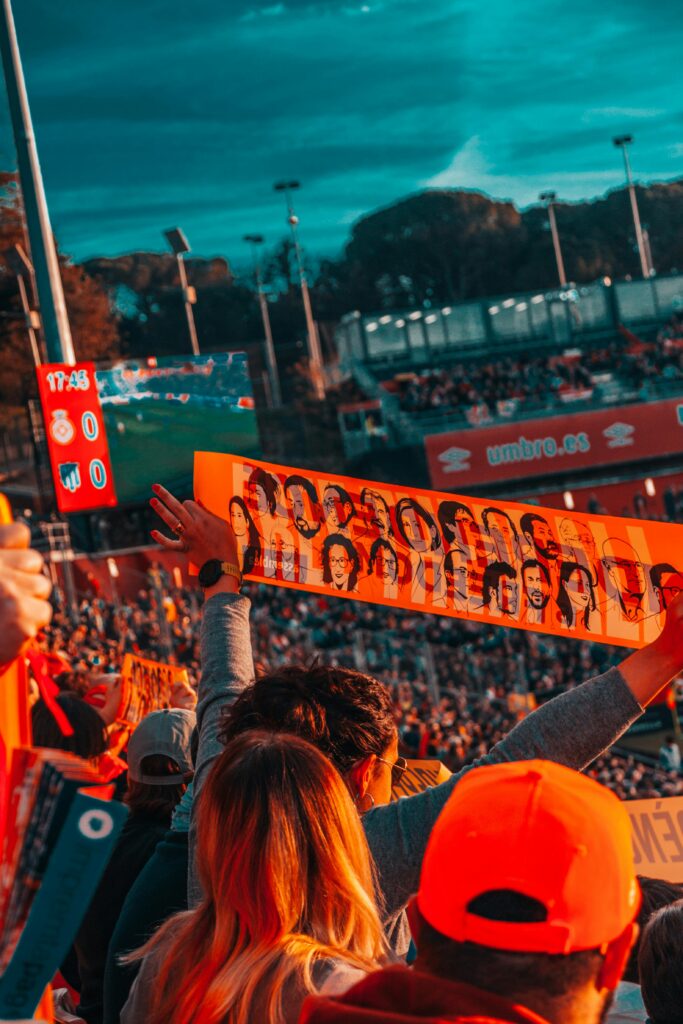 Dynamic scene of a lively crowd cheering at an outdoor sports event, capturing excitement and enthusiasm.